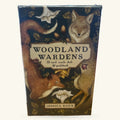 Woodland Wardens Oracle Cards box featuring illustrated woodland animals including a coyote, deer, and fox with botanical elements on a dark blue background