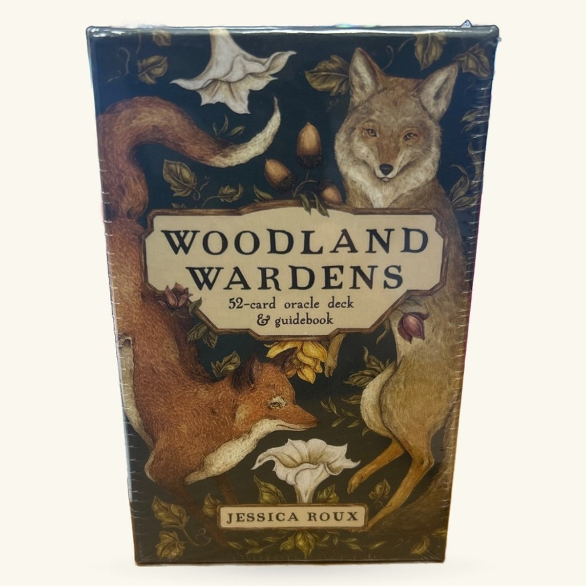 Woodland Wardens Oracle Cards box featuring illustrated woodland animals including a coyote, deer, and fox with botanical elements on a dark blue background
