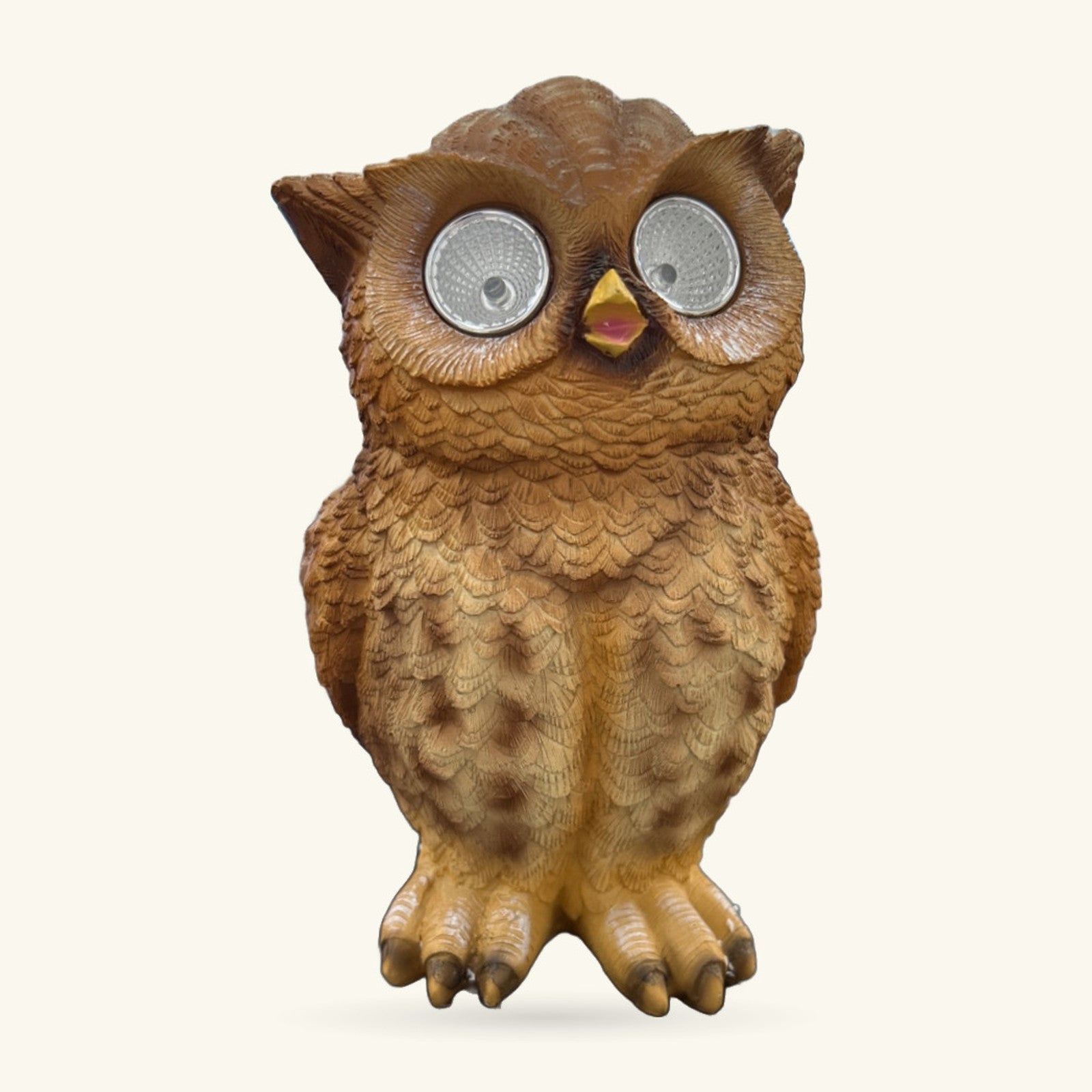 Brown carved wooden owl figurine with reflective silver eyes and yellow beak, standing upright against white background