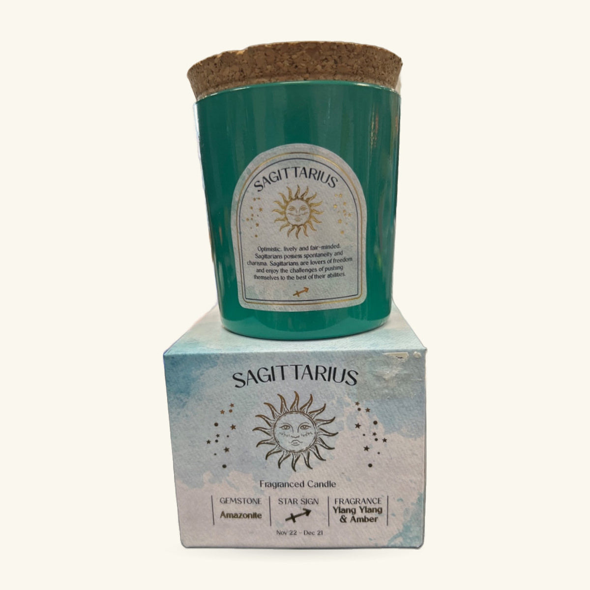 Sagittarius zodiac candle in green container with cork lid, displayed with light blue box packaging