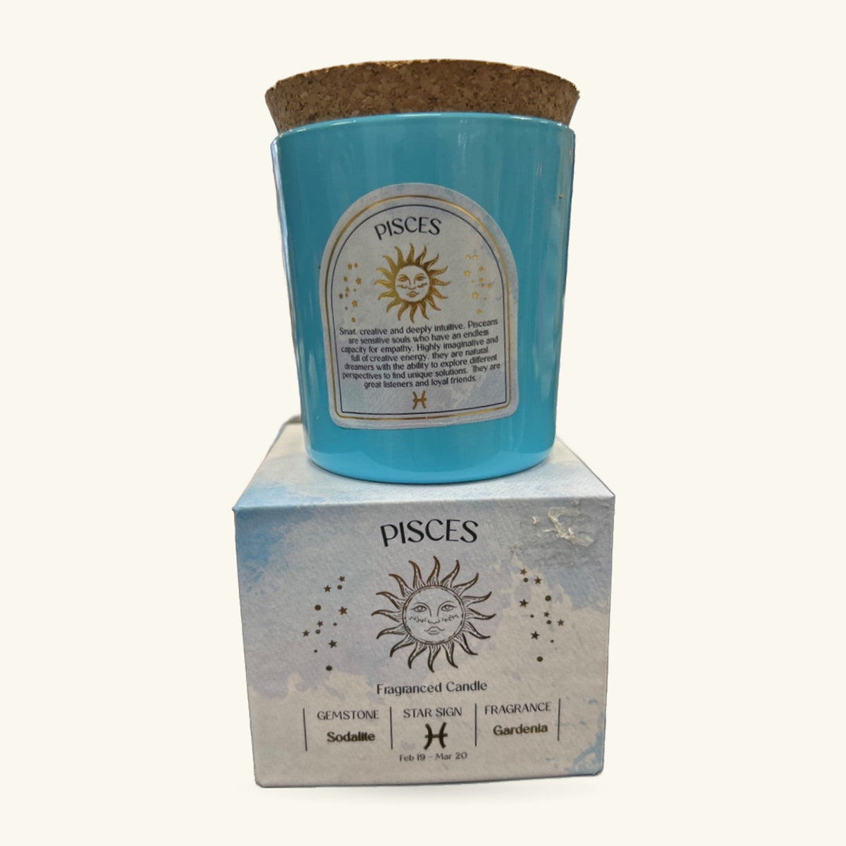 Pisces zodiac candle in turquoise glass with cork lid, shown with its white branded box