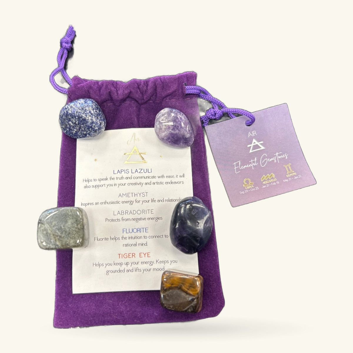 Purple velvet drawstring bag with six tumbled stones and an information card, plus a separate purple zodiac card.