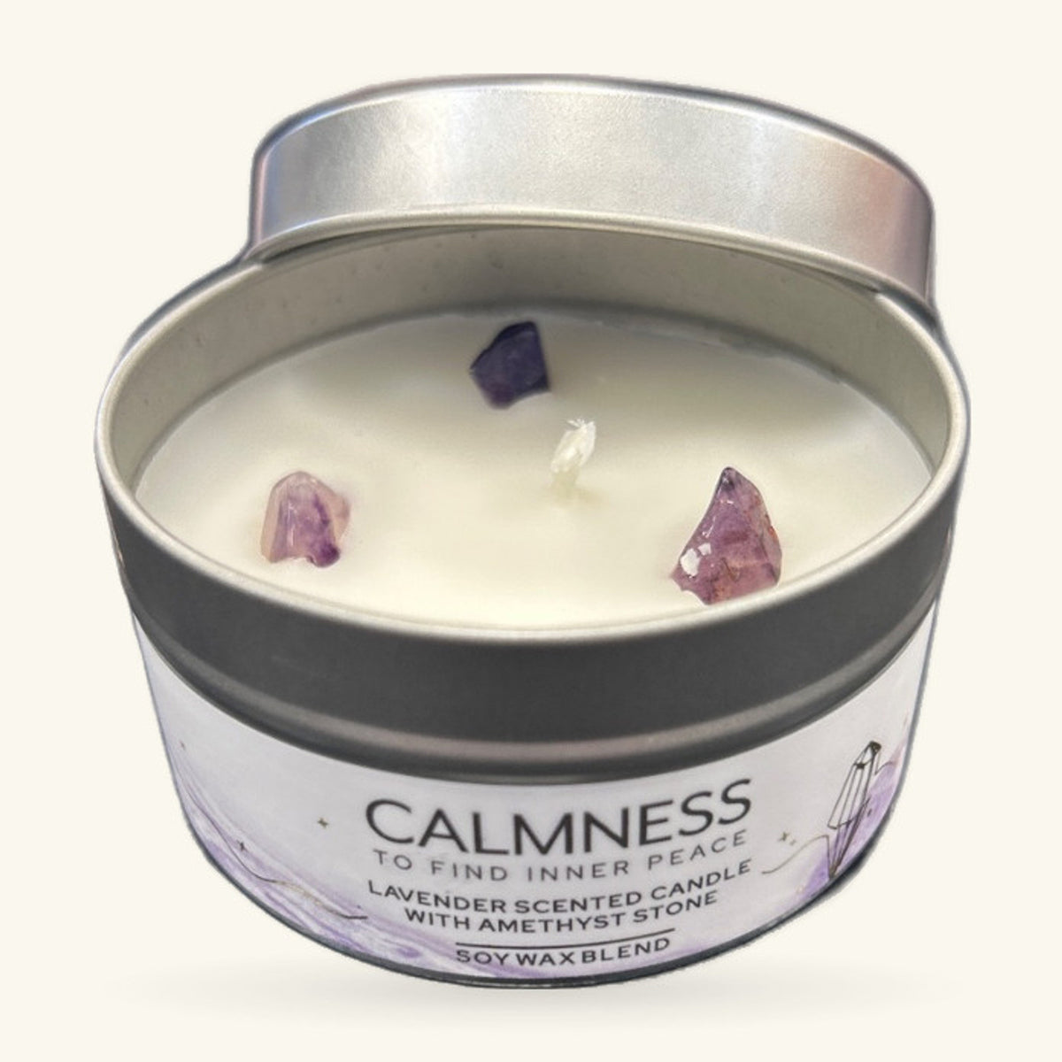 Small tin candle with cream soy wax, three raw amethyst chips embedded in the surface, silver lid