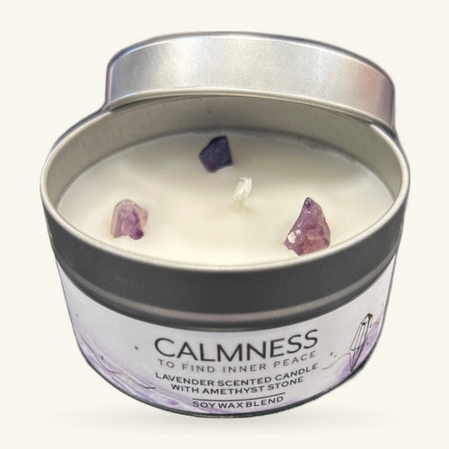 Small tin candle with cream soy wax, three raw amethyst chips embedded in the surface, silver lid