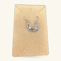 Pair of silver dandelion earrings on kraft paper display card with hook fasteners