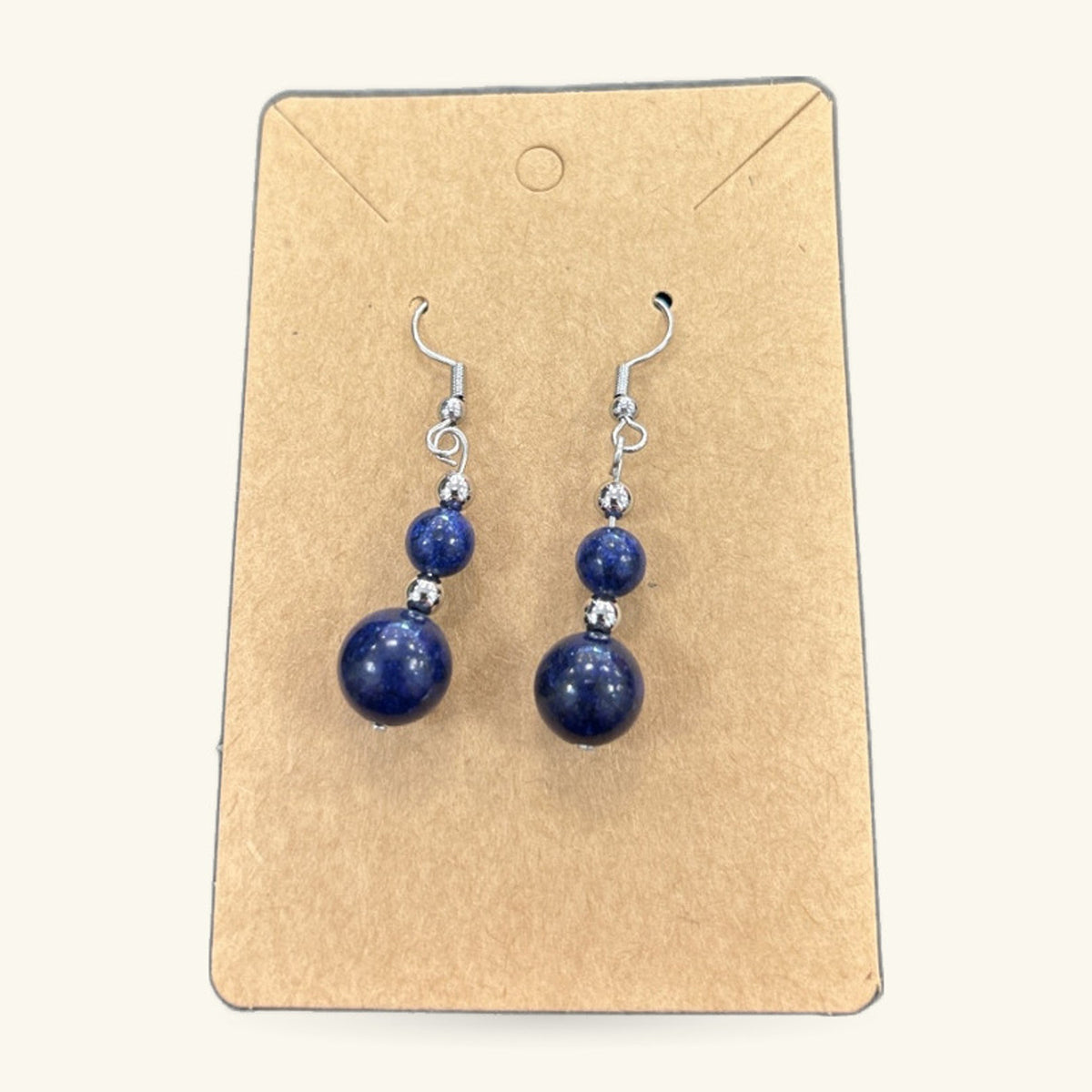 Pair of lapis lazuli bead earrings on kraft card display. Two-tier drop design with small and large round beads.