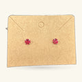 Pair of red prism stud earrings on a kraft paper earring card with envelope flaps