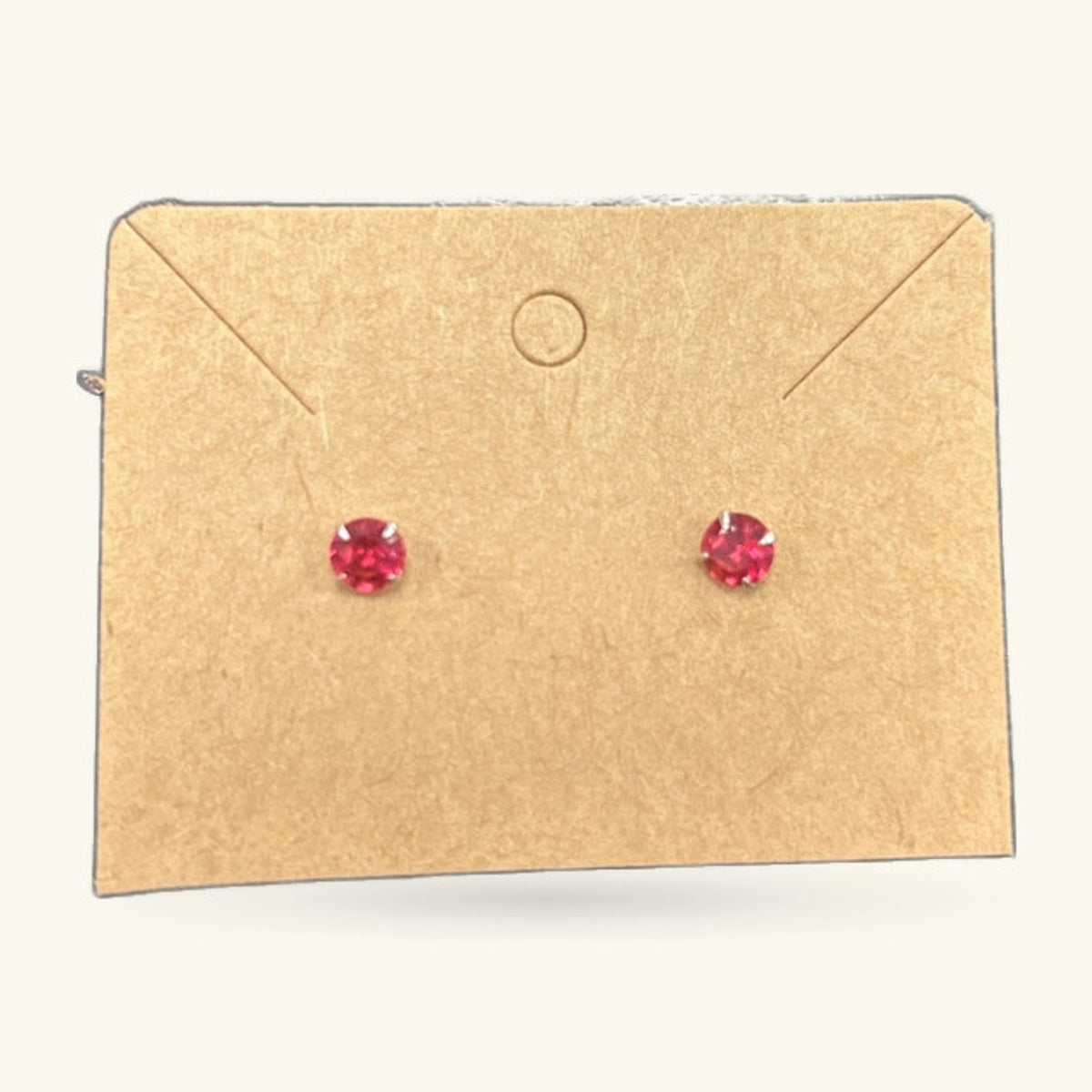 Pair of red prism stud earrings on a kraft paper earring card with envelope flaps