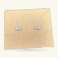 Pair of small silver lotus flower stud earrings on a kraft paper earring card