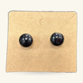 Pair of black glossy dome stud earrings on a kraft cardboard backing card