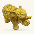 Gold glitter elephant figurine with beaded collar detail and yellow gem eye, side view