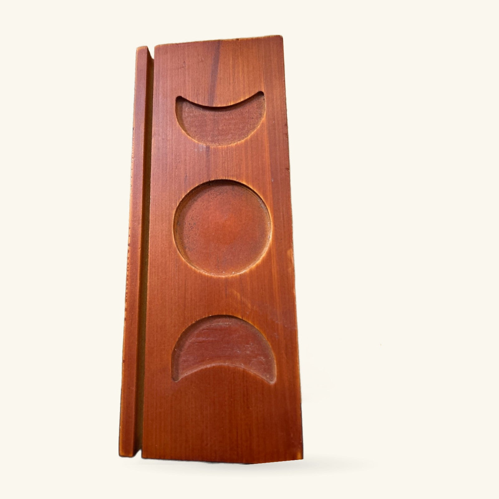 Wooden tarot card holder with three curved moon phases carved into warm reddish-brown timber