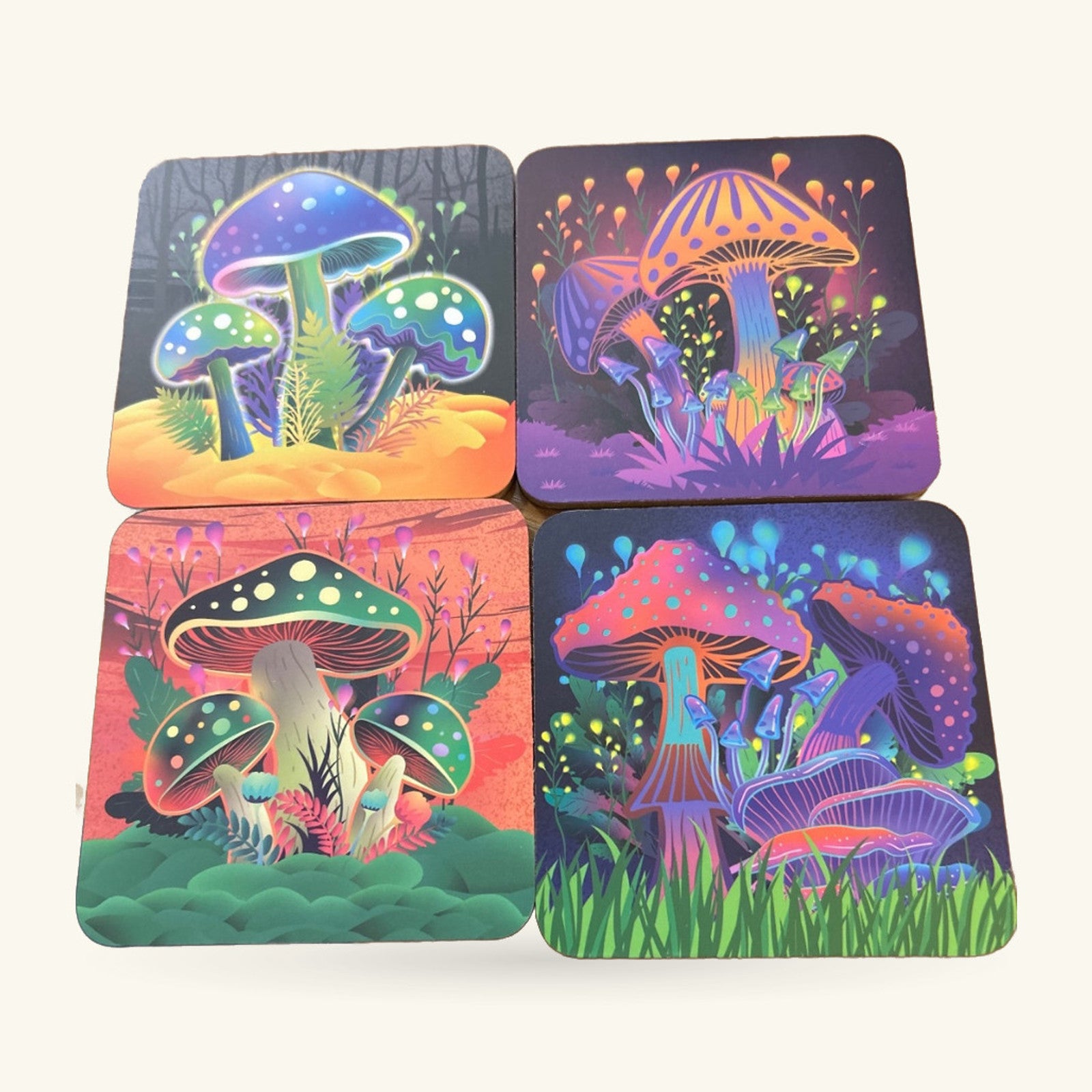 Four cork coasters with neon psychedelic mushroom designs in blues, purples, oranges and greens