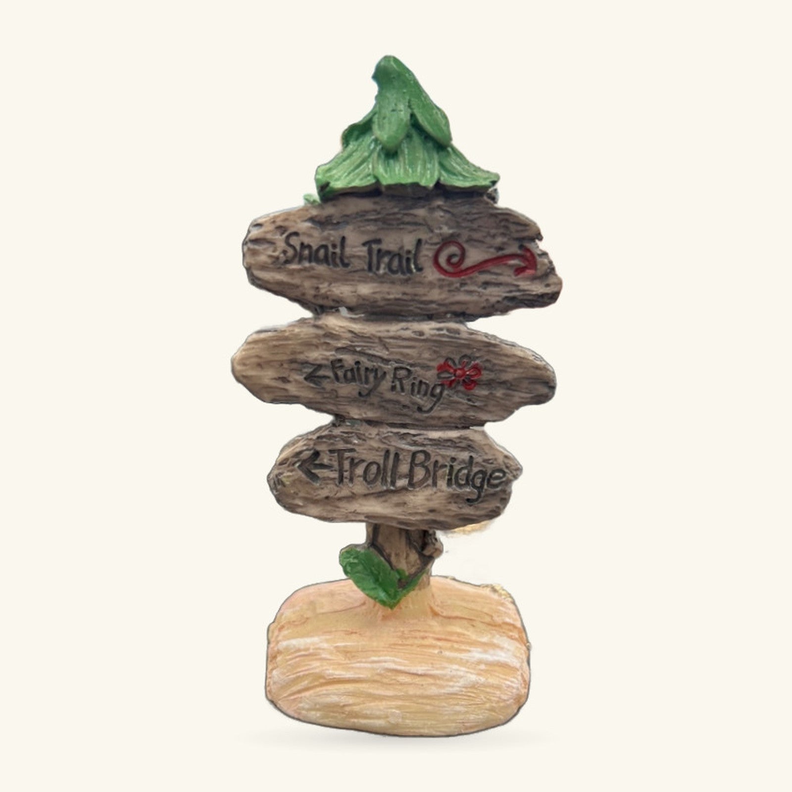 Stacked wooden signpost ornament with three carved arms reading Snail Trail, Fairy Ring, and Troll Bridge, topped with a green leaf finial
