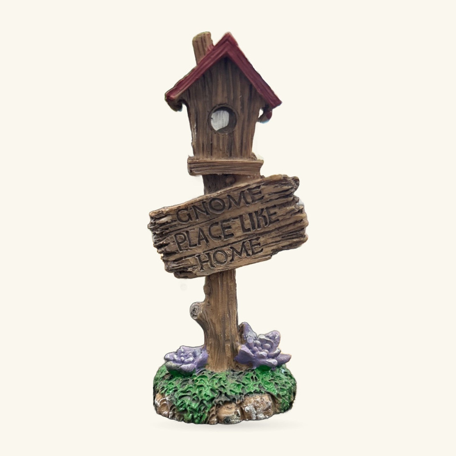 Wooden birdhouse ornament with burgundy roof on pole, 'Gnome Place Like Home' sign, moss base with purple flowers