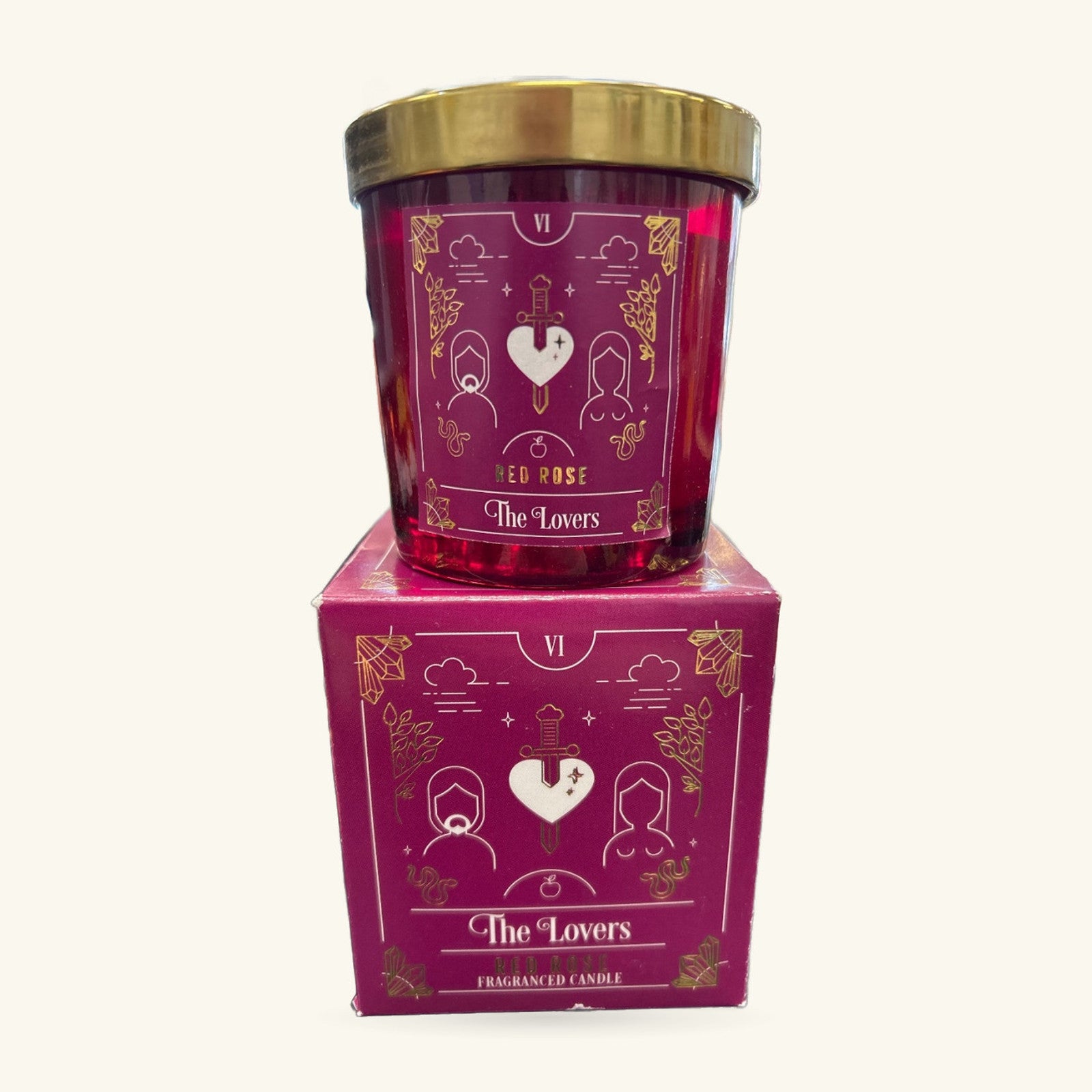 The Lovers red rose tarot candle in burgundy glass with gold foil labeling, displayed with its matching box