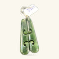 Pair of green greenstone dangle earrings with carved koru swirl detail, hung on gold-tone wires