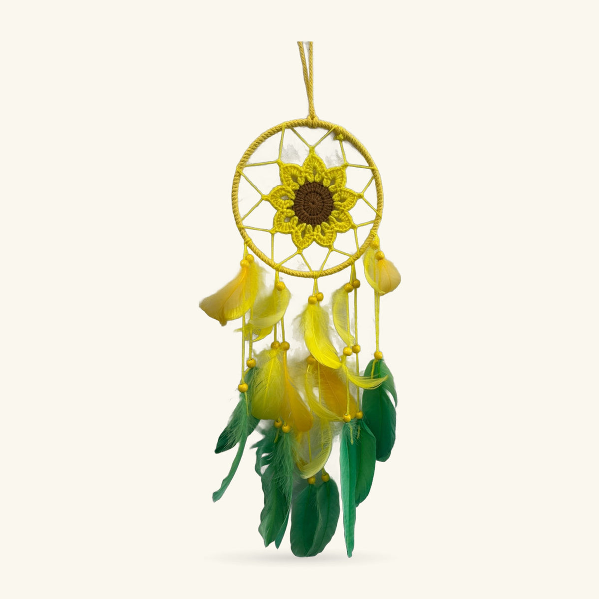 Yellow woven dreamcatcher with crocheted sunflower center and yellow and green feathers hanging below.