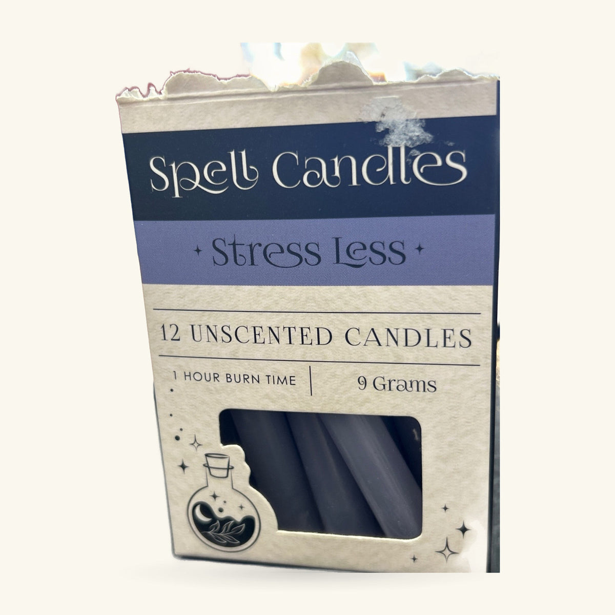Pack of 12 unscented grey spell candles with navy blue 'Stress Less' branding and potion bottle icon