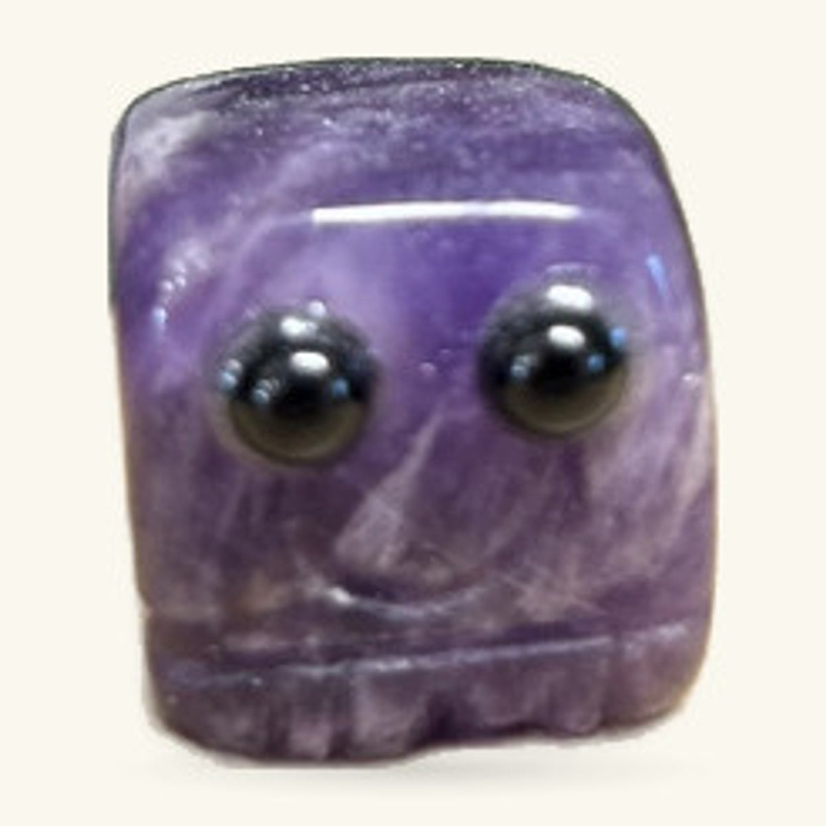 Purple amethyst block carved into a rounded square face with two black eyes and a simple smile