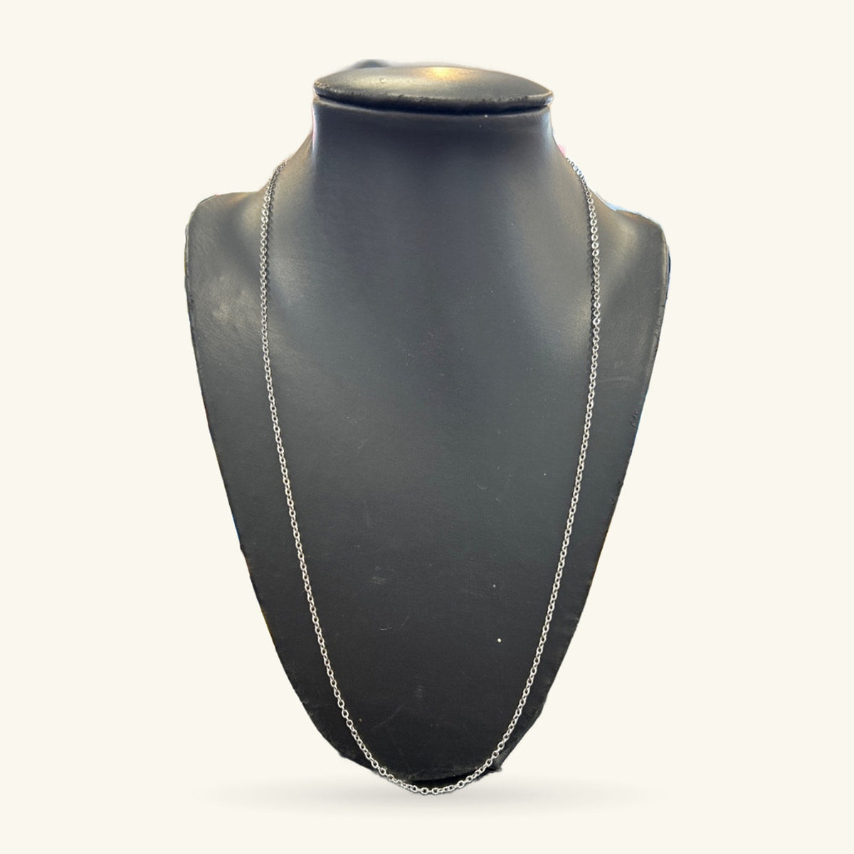 Silver chain necklace displayed on a black bust form, 60cm long.