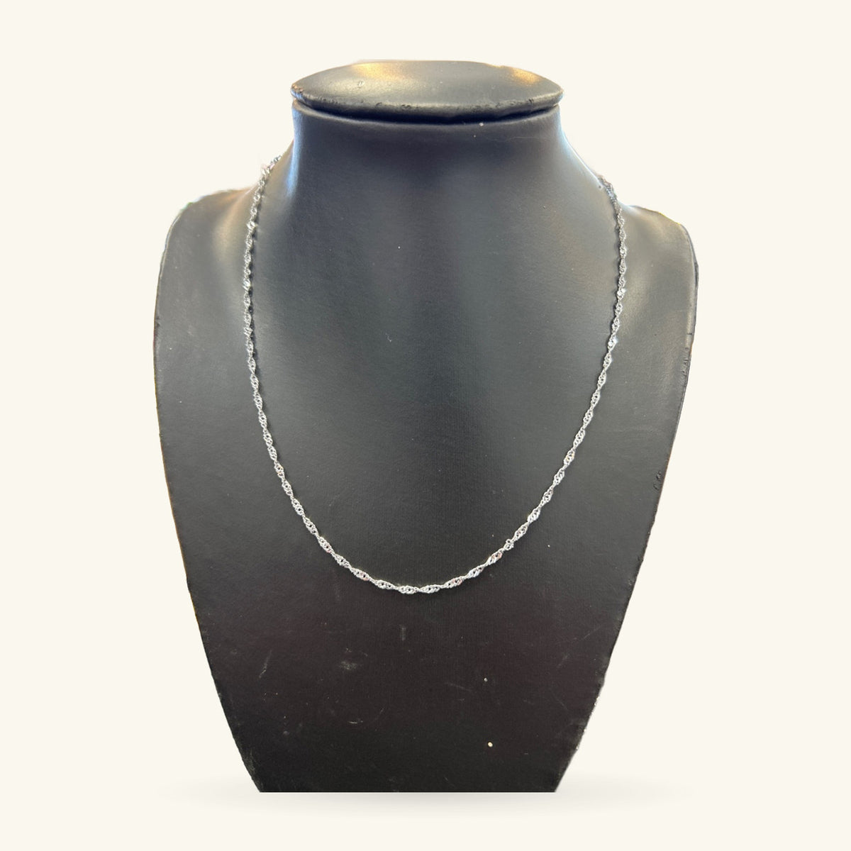 Silver twisted chain necklace displayed on a dark grey bust, 45cm length