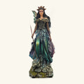 Tall fairy figurine with iridescent wings, ornate corset bodice, layered skirt in greens and blues, holding a staff