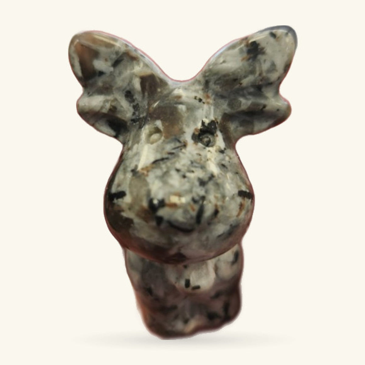 Moonstone reindeer head carving, cream and grey with black speckles, front view