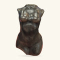 Dark polished obsidian torso carving, headless, with smooth curves and a wavy top edge