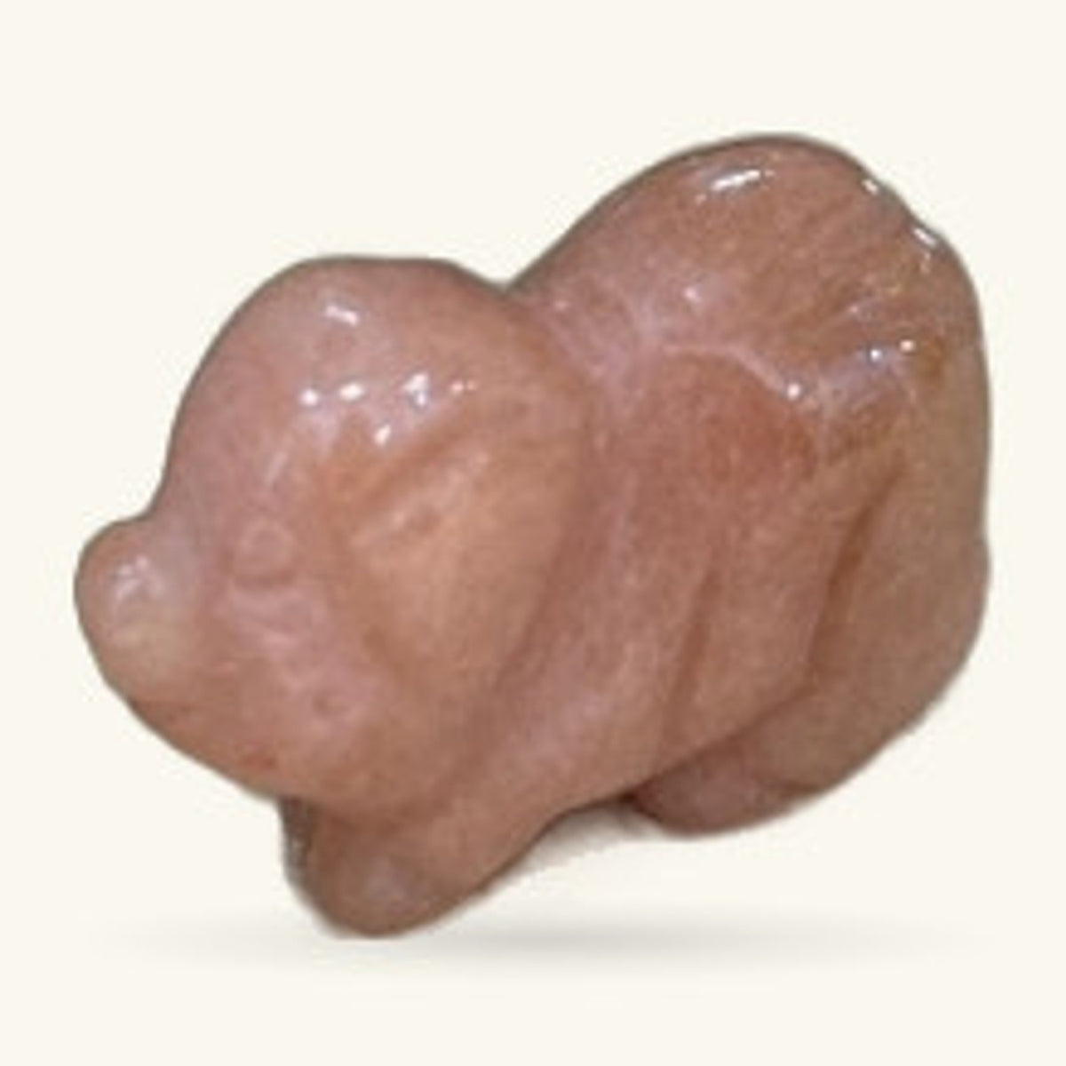 Polished strawberry quartz pig carving, light peachy-brown stone, sitting pose