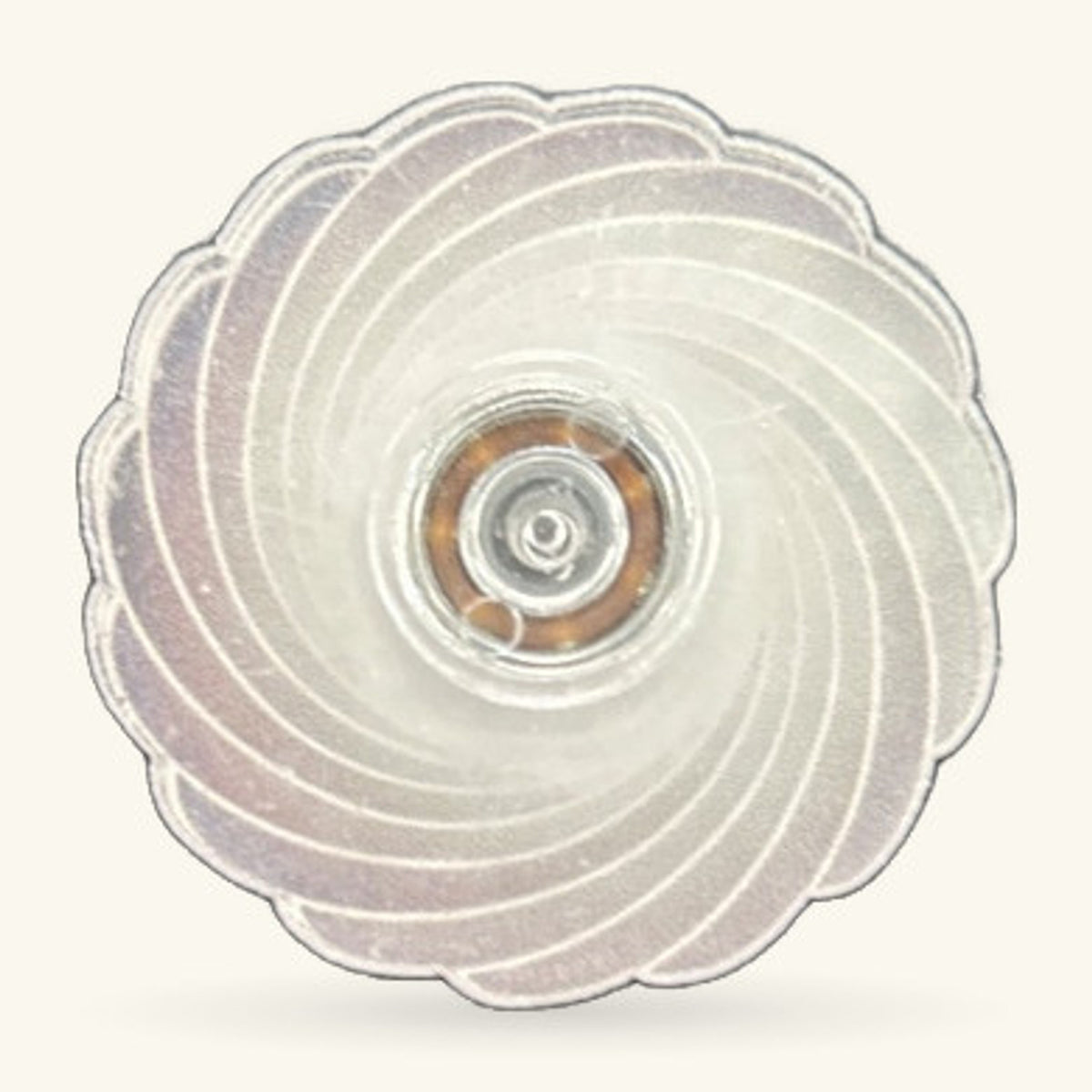 Grey and white fidget spinner with scalloped edges and central metal bearing, viewed from above