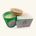 Green glass candle with cork lid and white gemstone-embedded wax, alongside its pale grey Leo zodiac gift box.