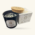 Black glass Scorpio candle with cork lid and cream wax top, displayed next to cream and white product box