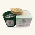 Green glass Libra candle with cork lid, displayed with its pale green zodiac-themed box and printed lid design