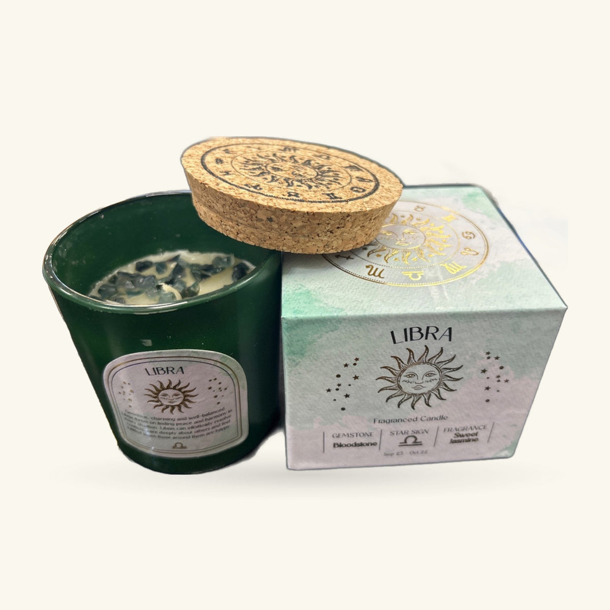 Green glass Libra candle with cork lid, displayed with its pale green zodiac-themed box and printed lid design