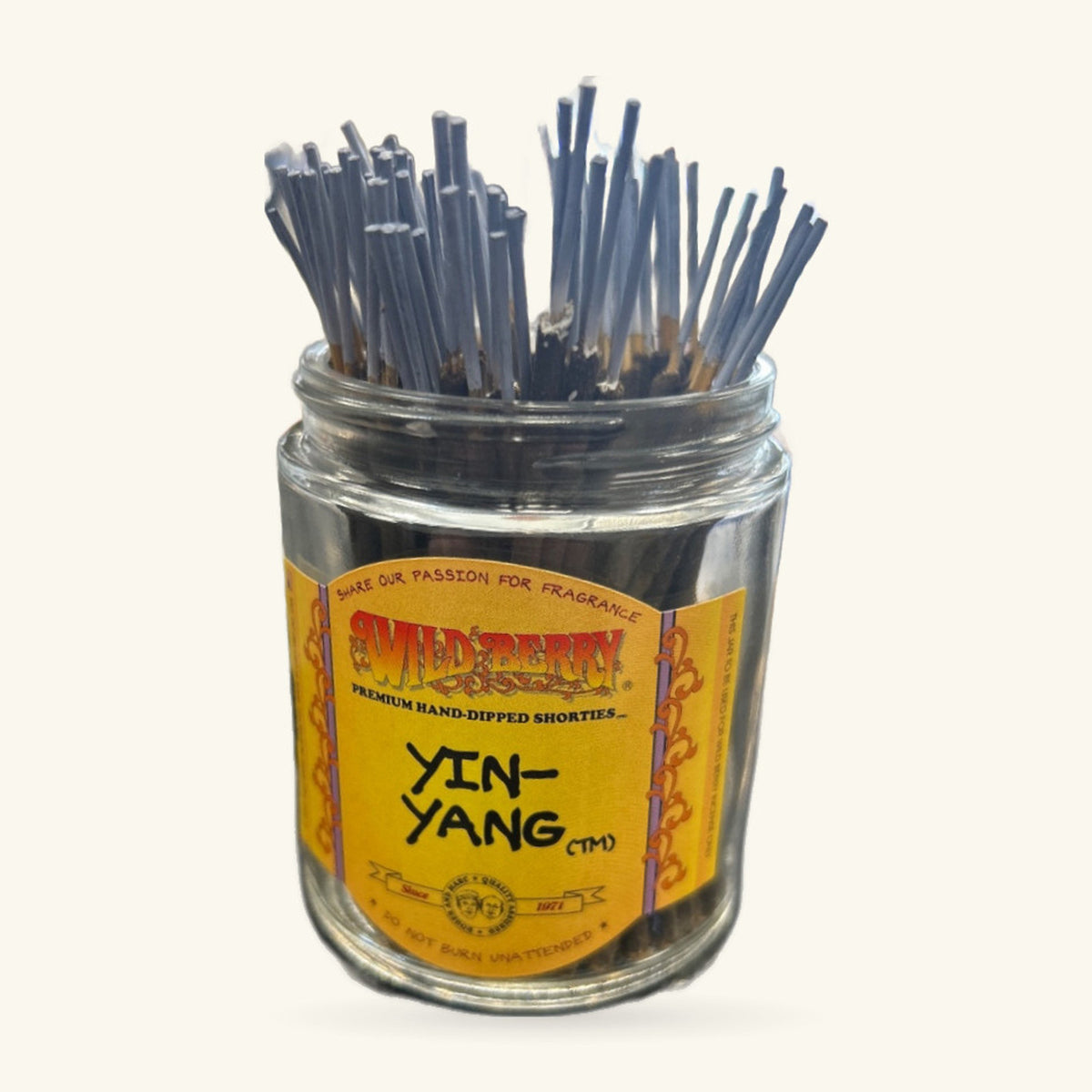 Glass jar of Wild Berry Yin-Yang incense sticks with yellow label, sticks bundled upright inside