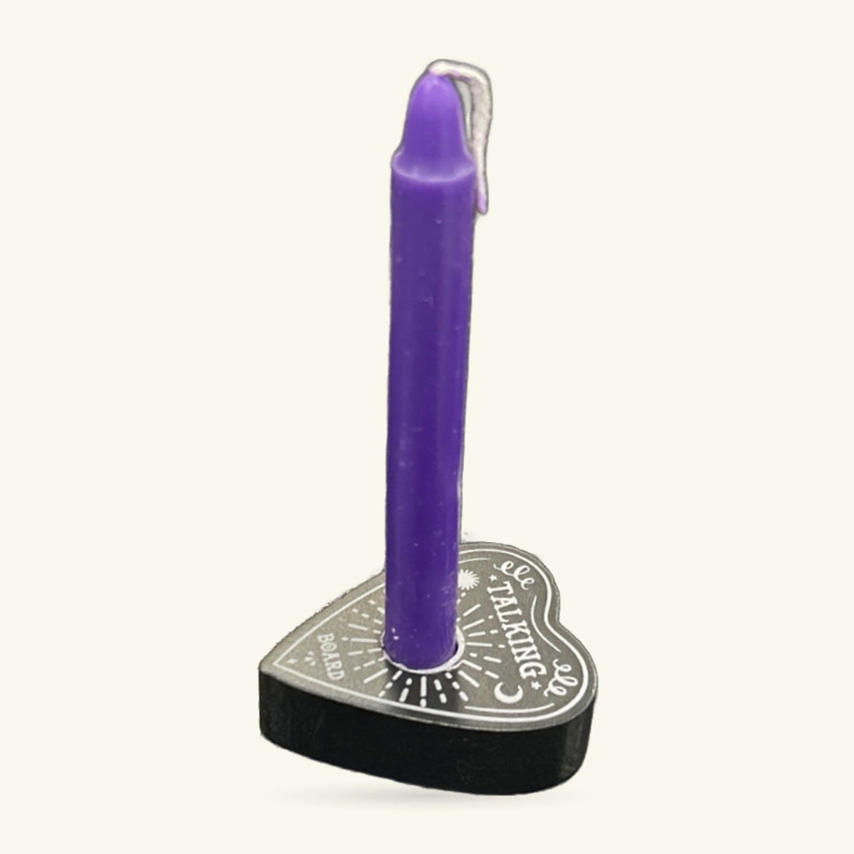 Purple spell candle in a heart-shaped black holder engraved with a talking board design and silver trim.