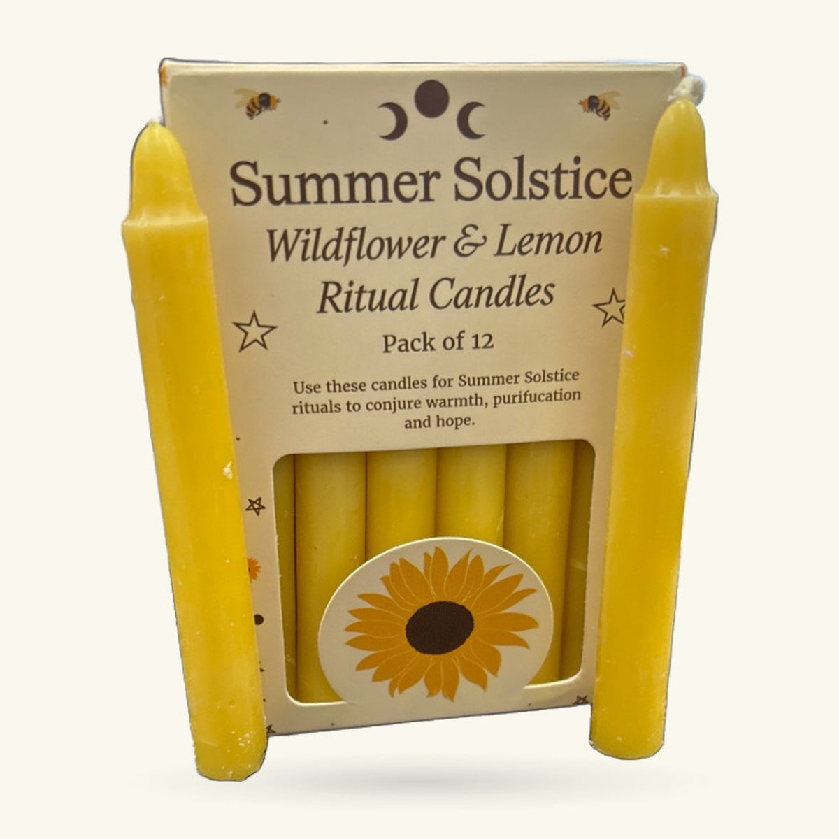 Pack of 12 yellow Summer Solstice ritual candles in cream packaging with wildflower illustration and decorative bee motifs