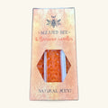 Pack of 6 natural orange beeswax candles in a hexagonal cardboard box with a bee logo