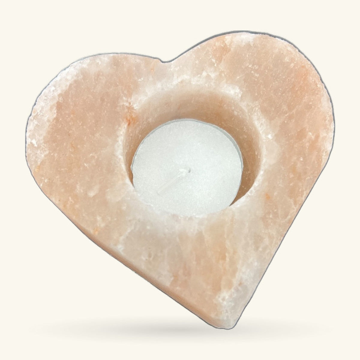 Heart-shaped Himalayan salt tea light holder with a white tea light nestled in the centre