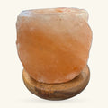 Himalayan salt tea light holder on wooden base, peachy-orange translucent stone with natural edges