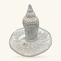 Cream ceramic buddha head incense holder with textured ushnisha, sitting on a round dish base