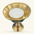 Gold metal tealight holder with pedestal base and wide flared bowl, white candle inside
