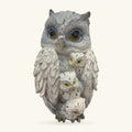 White ceramic owl ornament with three smaller owls nestled against its body, all with yellow eyes
