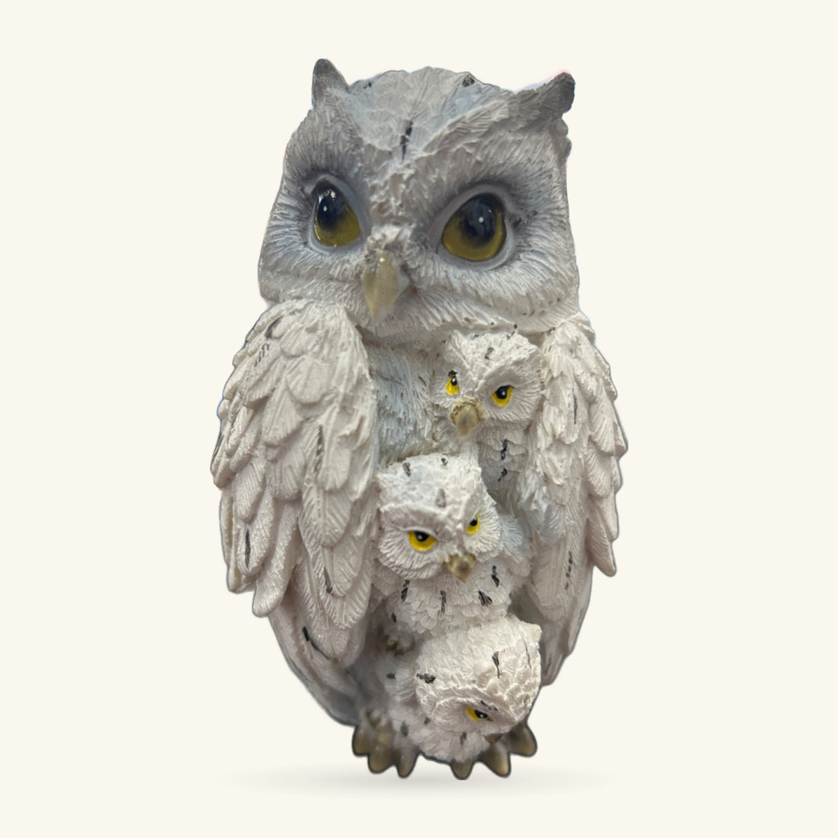 White ceramic owl ornament with three smaller owls nestled against its body, all with yellow eyes