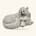 White resin ornament of a wolf pup sitting on a mother wolf's back, both with gentle expressions