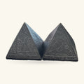 Two black stone pyramids with Egyptian hieroglyph carvings, shown front and back