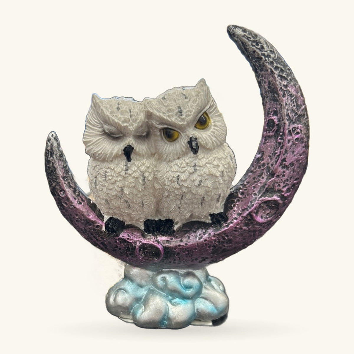 White owl perched on a crescent moon in purple and grey, sitting on a pale blue cloud base.