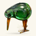 Green glass kiwi bird ornament with amber-toned legs and beak, shown against a white background